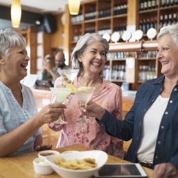 Bustling community with plenty of dining choices A group of people sharing a drinks and a meal together at Rosalia Winter Park apartments in Winter Park, FL.