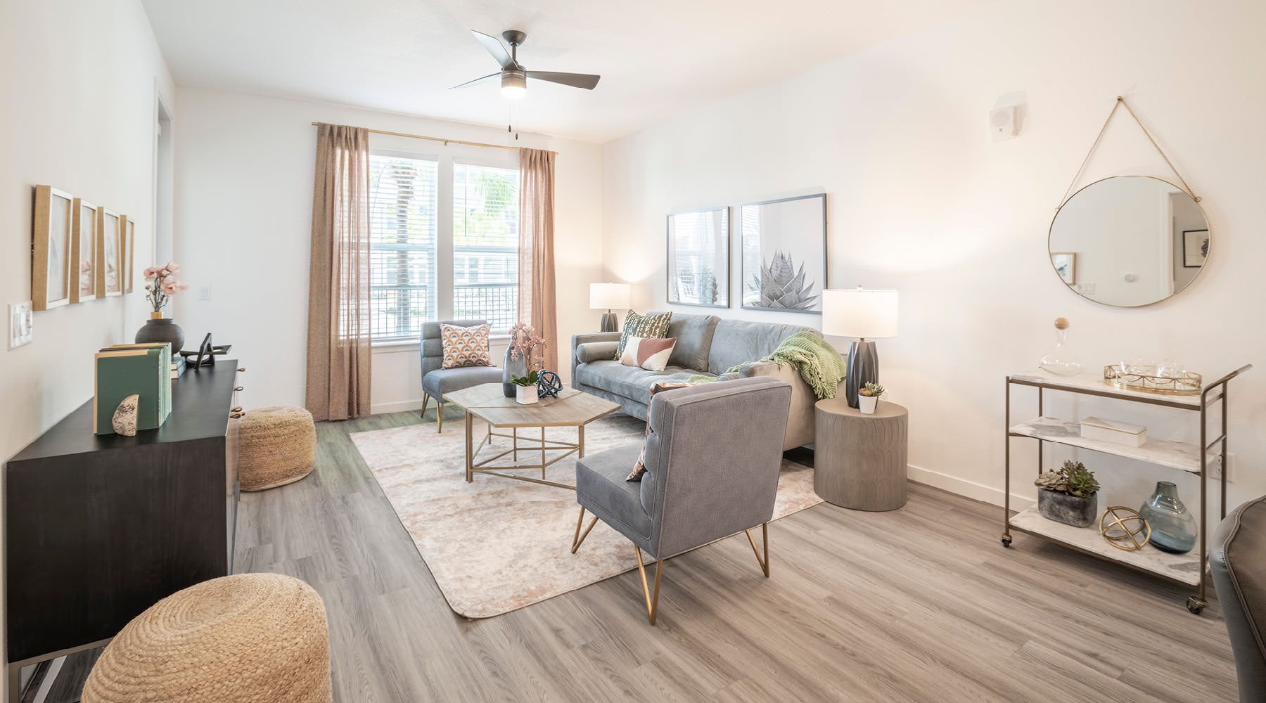 Beautiful living spaces with natural lighting Model living room at Rosalia Winter Park apartments in Winter Park, FL, featuring wood grain flooring and large windows.