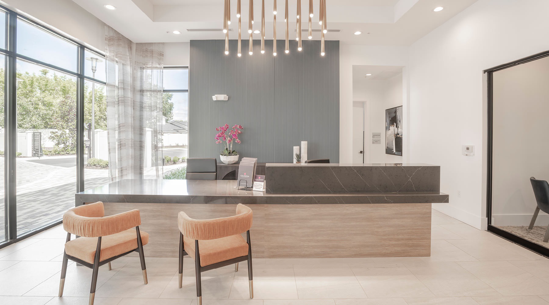 Find your perfect fit at Rosalia Winter Park Lobby at Rosalia Winter Park apartments in Winter Park, FL, featuring a front desk with chairs, and modern decor.