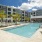 Outdoor swimming pool at Rosalia Winter Park apartments in Winter Park, FL, featuring lounge chairs and palm trees.